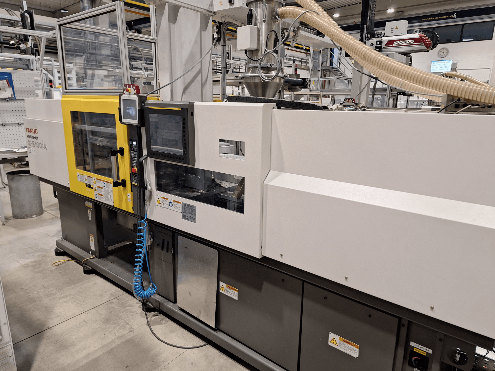 FANUC Roboshot α-S300iA -ruiskuvalukone, etukuva, jossa on ohjauspaneeli ja näkyviä teollisuuskomponentteja.